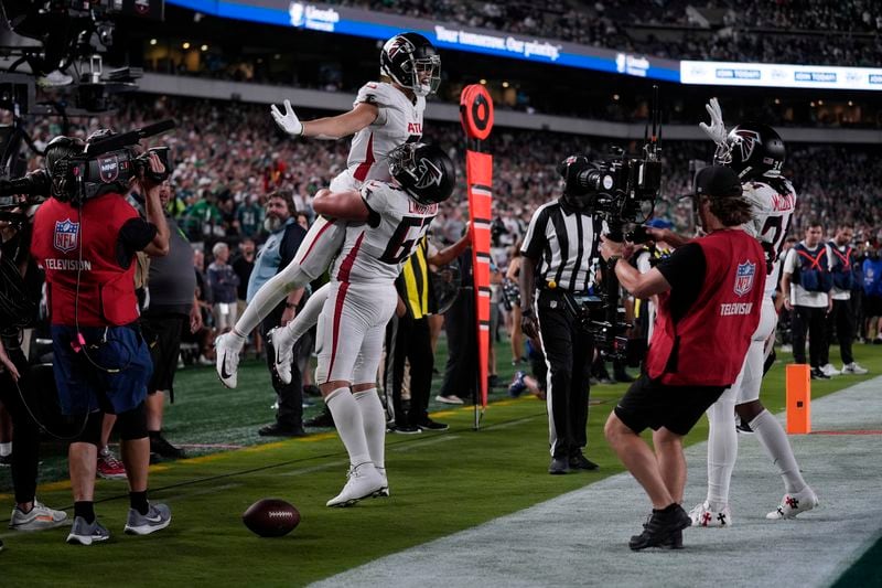 Atlanta Falcons wide receiver Drake London (5) celebrates his touchdown with teammate Chris Lindstrom (63) during the second half of an NFL football game against the Philadelphia Eagles on Monday, Sept. 16, 2024, in Philadelphia. (AP Photo/Matt Rourke)