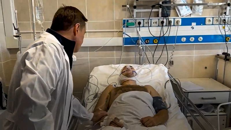 In this photo taken from video released by Moscow Region Governor Andrei Vorobyev official telegram channel, Moscow Region Governor Andrei Vorobyev, back to the camera, visits a wounded man after an alleged Ukrainian drone attack on multi-storey residential building prior to be transferred to a Moscow's hospital, in Ramenskoye, outside Moscow, Moscow region, Russia, on Tuesday, Sept. 10, 2024. (Moscow Region Governor Andrei Vorobyev official telegram channel via AP)