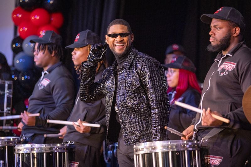 Usher appears for a homecoming rally at Clark Atlanta University in Atlanta on Wednesday, February 14, 2024, while the CAU marching band plays. Along with other honors, Amazon presented a $25,000 donation to Usher’s New Look Foundation. (Arvin Temkar / arvin.temkar@ajc.com)