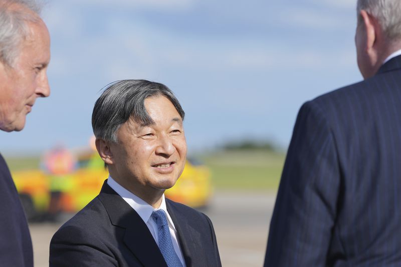 Emperor Naruhito is greeted by dignitaries has he and Empress Masako arrive at Stansted Airport, England, Saturday, June 22, 2024, ahead of a state visit. The state visit begins Tuesday, when King Charles III and Queen Camilla will formally welcome the Emperor and Empress before taking a ceremonial carriage ride to Buckingham Palace. (AP Photo/Kin Cheung)