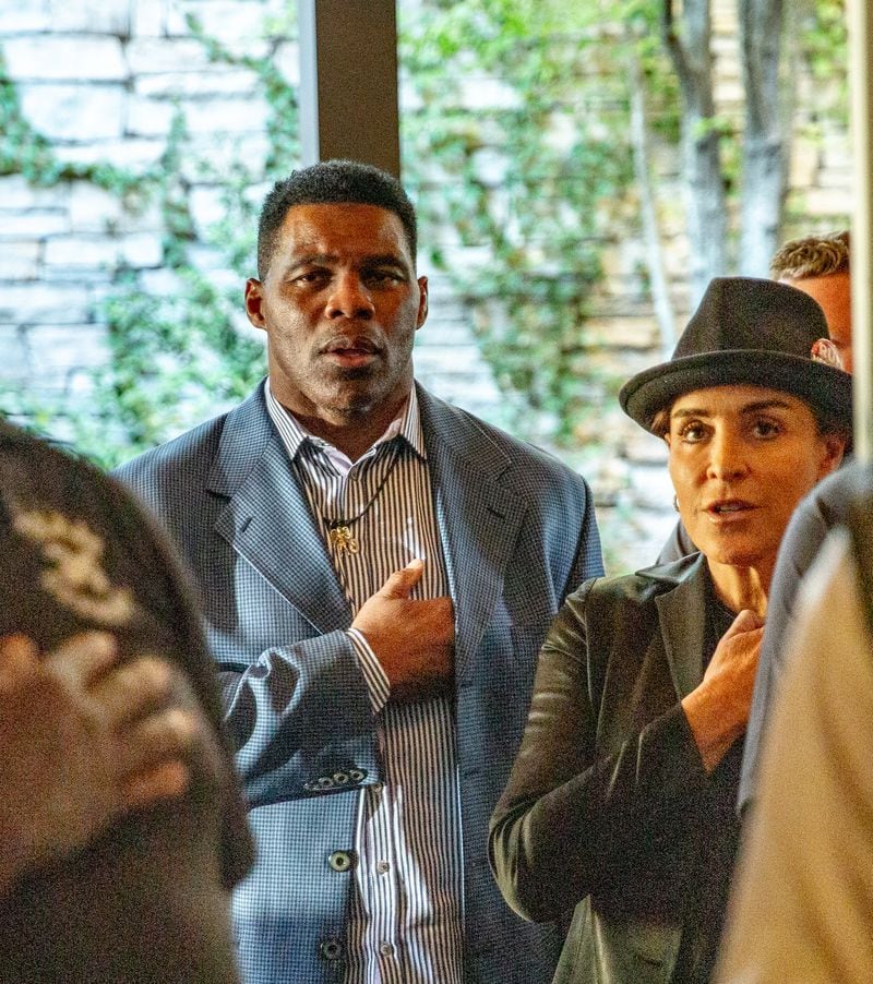 Herschel Walker and his wife, Julie Blanchard, recite “The Pledge of Allegiance” during a September campaign stop at Mojitos Bistro in Norcross. (Jenni Girtman for The Atlanta Journal-Constitution)