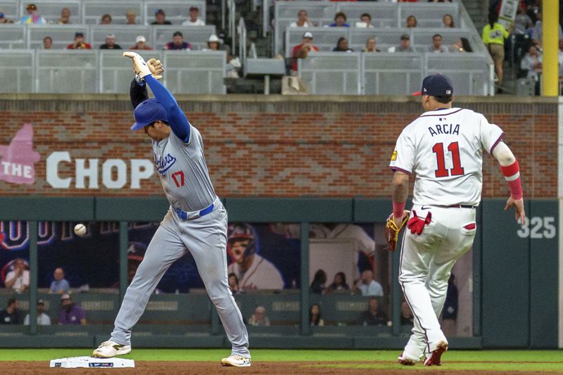 Los Angeles Dodgers' Shohei Ohtani, left, tags second base before Atlanta Braves shortstop Orlando Arcia, right, can get the ball in the seventh inning of a baseball game, Monday, Sept. 16, 2024, in Atlanta. (AP Photo/Jason Allen)