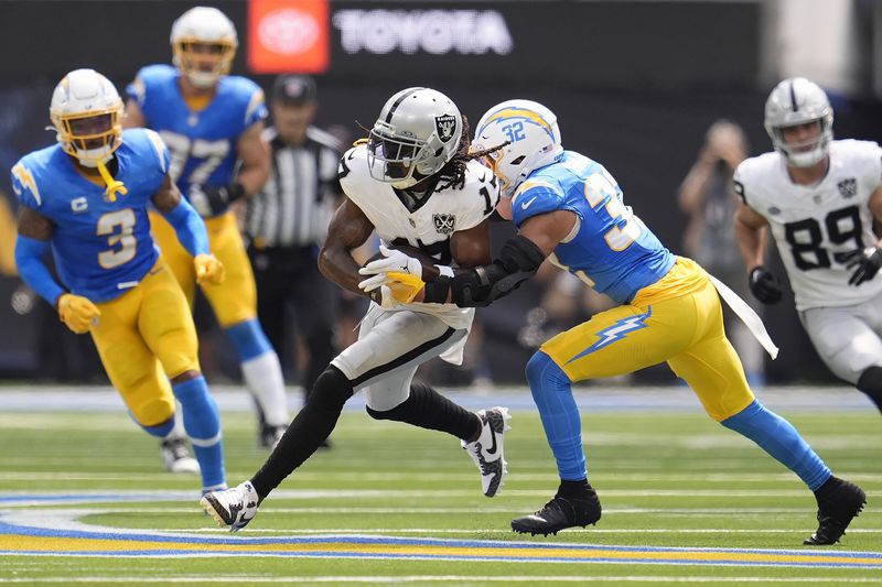 Las Vegas Raiders wide receiver Davante Adams, middle, runs against Los Angeles Chargers safety Alohi Gilman (32) during the first half of an NFL football game, Sunday, Sept. 8, 2024, in Inglewood, Calif. (AP Photo/Marcio Jose Sanchez)