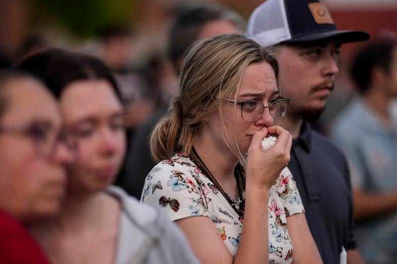 Mourners pray during a candlelight vigil on Wednesday for the slain students and teachers at Apalachee High School in Winder.