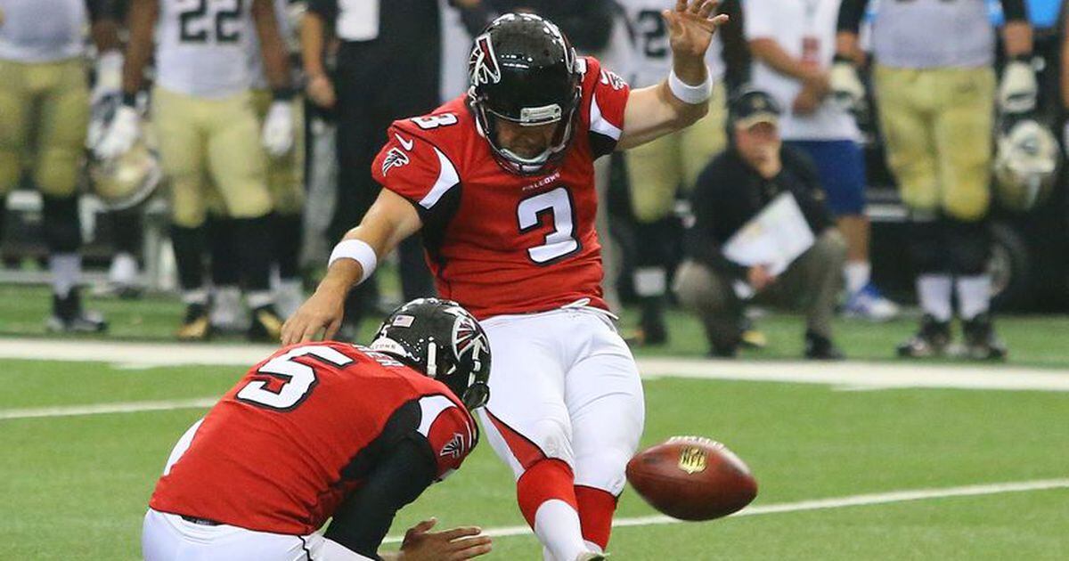 Atlanta Falcons wide receiver Julio Jones autographs a football