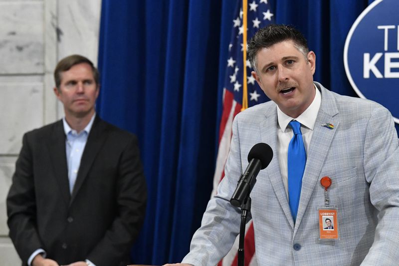 Chris Hartman, right, Executive Director of the Fairness Campaign, speaks to the audience gathered in the Capitol Rotunda to celebrate after Kentucky Gov. Andy Beshear, left, signed an executive order banning the use of “conversion therapy” on minors, Wednesday, Sept. 18, 2024, in Frankfort, Ky. (AP Photo/Timothy D. Easley)