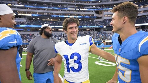 Los Angeles Rams quarterback Stetson Bennett, center, talks to Los Angeles Chargers wide receiver Ladd McConkey (15) after a preseason NFL football game Saturday, Aug. 17, 2024, in Inglewood, Calif. (AP Photo/Jayne Kamin-Oncea)