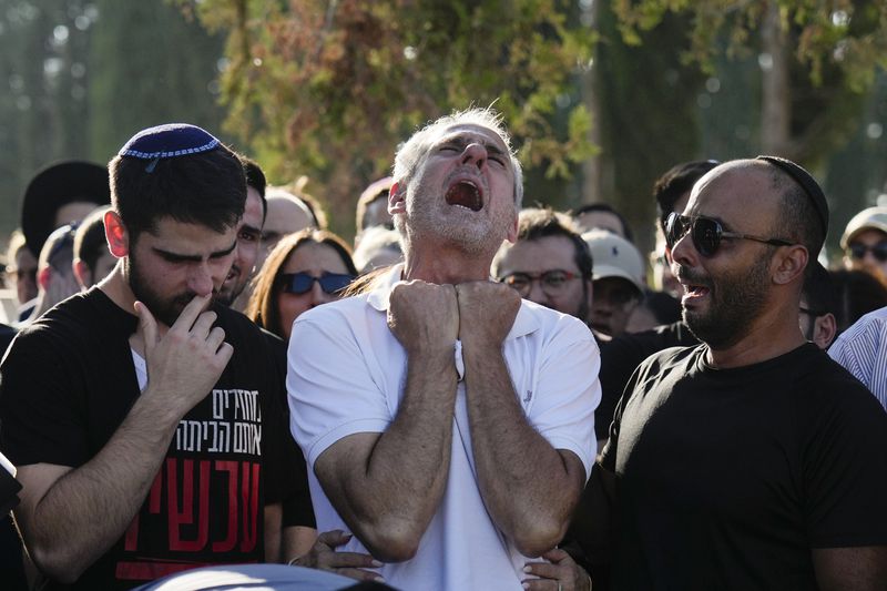 Yigal Sarusi, center, mourns during the funeral of his son, slain hostage Almog Sarusi, who was killed in Hamas captivity in the Gaza Strip, at a cemetery in Ra'anana, Israel, Sunday, Sept. 1, 2024. (AP Photo/Ariel Schalit)