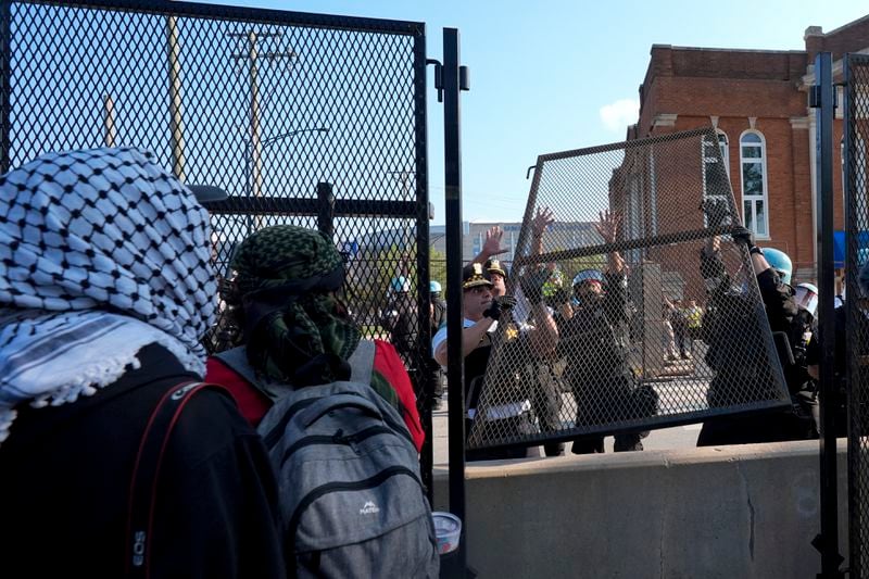 Please replace a piece of fence knocked down by protesters surrounding the United Center at the Democratic National Convention after a march Monday, Aug. 19, 2024, in Chicago. (AP Photo/Frank Franklin II)