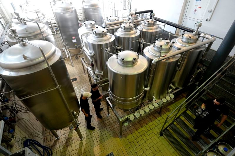 Employees of the Technical University of Munich work at the brewery plant in Freising, Germany, Thursday, Sept. 19, 2024. (AP Photo/Matthias Schrader)