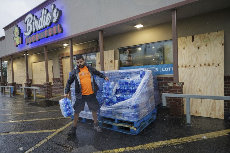 A customer buys water at a mostly boarded up Birdies Food and Fuel, Wednesday, Sept. 11, 2024, in Luling, La., ahead of Hurricane Francine. (David Grunfeld/The Times-Picayune/The New Orleans Advocate via AP)