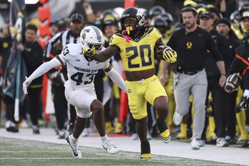 Oregon running back Jordan James (20) runs ahead of Michigan State defensive back Malik Spencer (43) during the first half of an NCAA college football game, Friday, Oct. 4, 2024, in Eugene, Ore. (AP Photo/Amanda Loman)