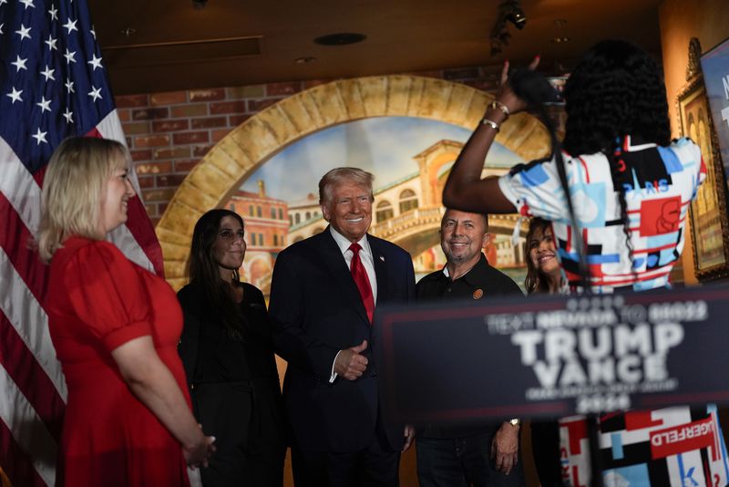 Republican presidential nominee former President Donald Trump poses for a photo at a campaign event at ll Toro E La Capra, Friday, Aug. 23, 2024, in Las Vegas. Second from right is restaurant owner Javier Barajas.(AP Photo/Julia Nikhinson)