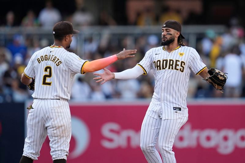 San Diego Padres right fielder Fernando Tatis Jr., right, celebrates with teammate second baseman Xander Bogaerts after the Padres defeated the Detroit Tigers 3-0 in a baseball game Monday, Sept. 2, 2024, in San Diego. (AP Photo/Gregory Bull)