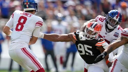 Cleveland Browns defensive end Myles Garrett (95) reaches for New York Giants quarterback Daniel Jones (8) while being blocked by offensive tackle Andrew Thomas (78) during the first half of an NFL football game, Sunday, Sept. 22, 2024 in Cleveland. (AP Photo/Sue Ogrocki)