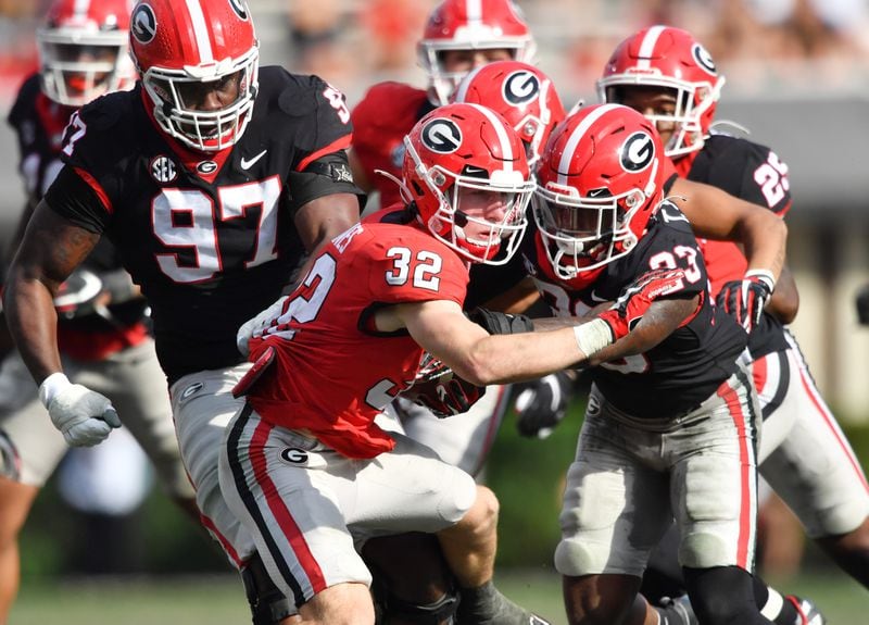 Georgia running back Cash Jones (32) gets tackled by Georgia defensive back Tykee Smith (right) during the G-Day game at Sanford Stadium, Saturday, April 15, 2023, in Athens. (Hyosub Shin / Hyosub.Shin@ajc.com) 