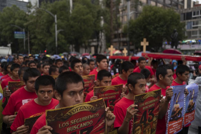 Youths take part in a demonstration marking the 10-year anniversary of the disappearance of 43 Ayotzinapa rural teacher's college students, in Mexico City, Thursday, Sept. 26, 2024. (AP Photo/Jon Orbach)