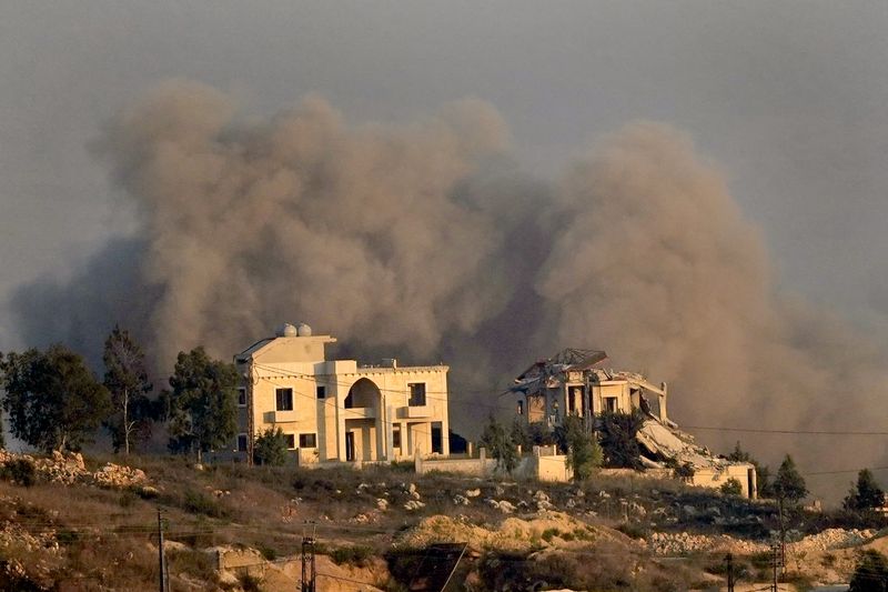 Smoke rises behind a destroyed house following an Israeli airstrike on Khiam village, as seen from Marjayoun town, south Lebanon, Tuesday, Sept. 24, 2024. (AP Photo/Hussein Malla)