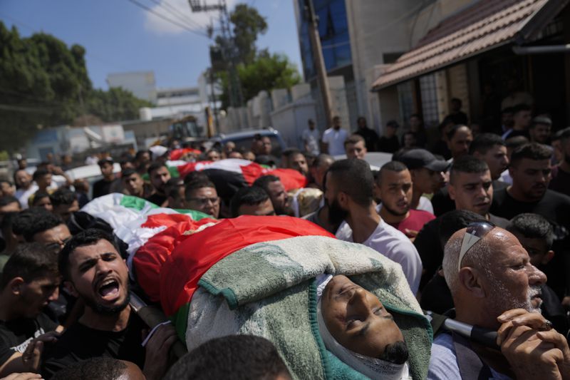 Mourners take part in a funeral of four Palestinians who died during an Israeli military operation in the West Bank refugee camp of Al-Faraa, near Tubas, Thursday, Aug. 29, 2024. (AP Photo/Nasser Nasser)