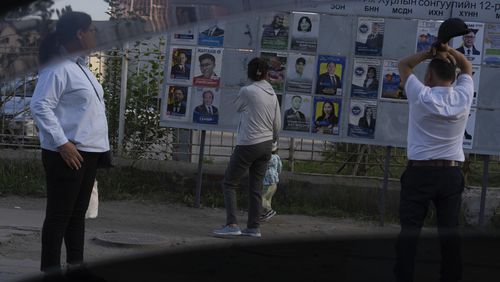Residents look at election posters of candidates, two days before polls open in Ulaanbaatar, Mongolia, June 26, 2024. As a democracy of just 3.4 million people in the shadow of two much larger authoritarian states, China and Russia, it has taken on symbolic importance in an era when democracy is under pressure or in crisis in many countries, including the United States. (AP Photo/Ng Han Guan)