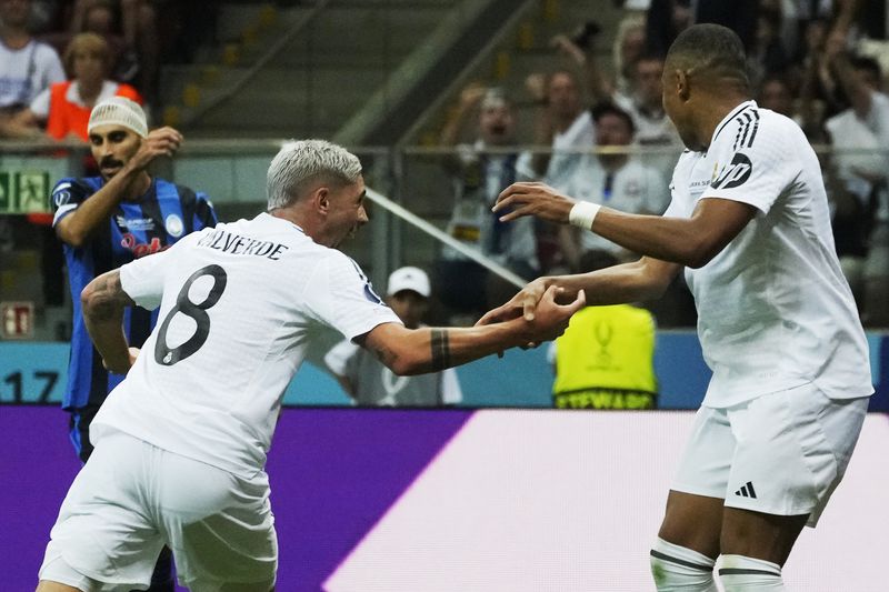 Real Madrid's Federico Valverde, centre, celebrates with Kylian Mbappe after scoring the opening goal during the UEFA Super Cup Final soccer match between Real Madrid and Atalanta at the Narodowy stadium in Warsaw, Poland, Wednesday, Aug. 14, 2024. (AP Photo/Czarek Sokolowski)