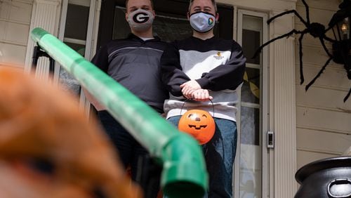 201016-Atlanta-Heath Hall, left, and Ben Ku aren’t sure how many trick-or-treaters they will get this year at their Tucker home, so they built a chute to deliver candy while keeping socially distanced on Halloween. Ben Gray for the Atlanta Journal-Constitution