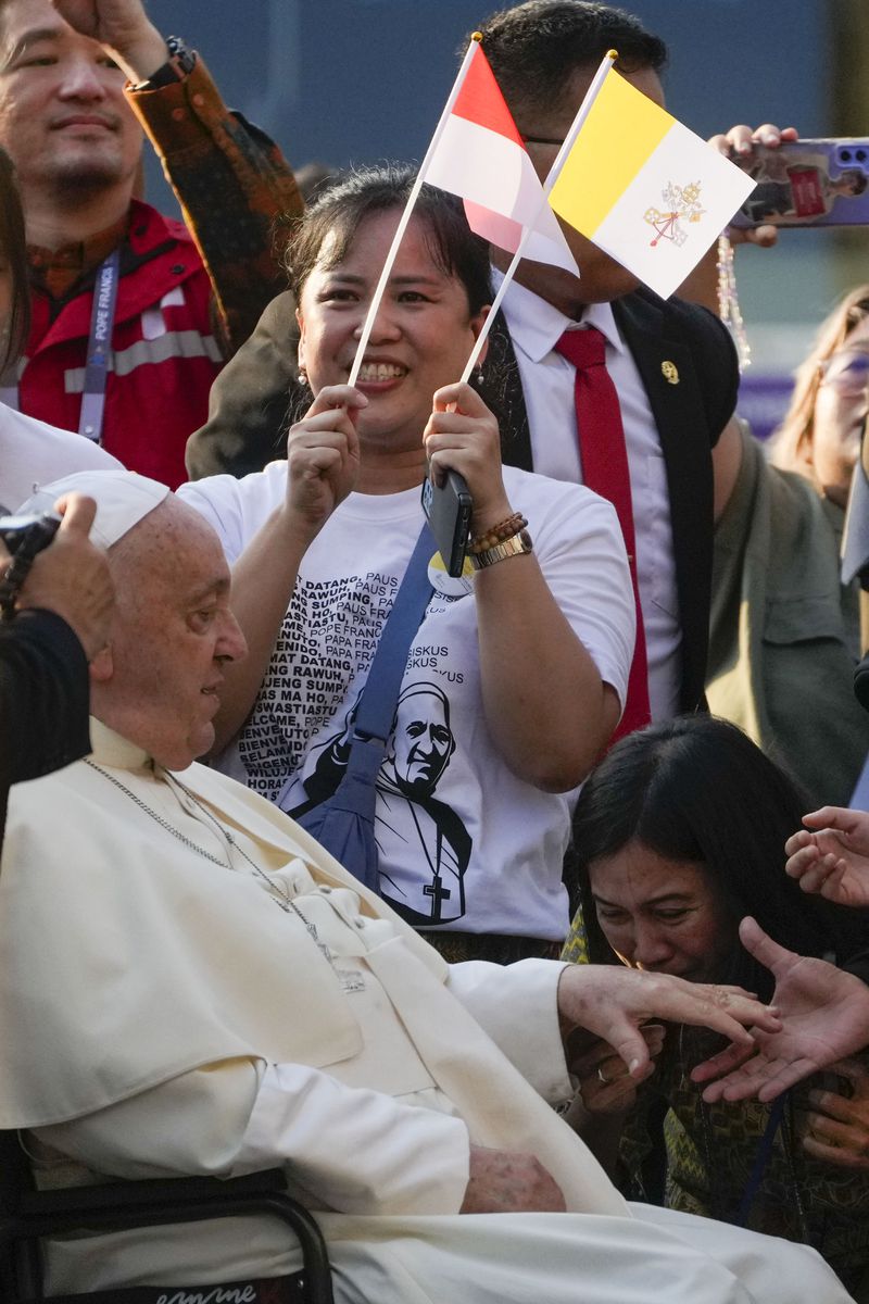 Pope Francis is greeted by faithful as he arrives at the Cathedral of Our Lady of the Assumption in Jakarta, Wednesday, Sept. 4, 2024. Pope Francis urged Indonesia to live up to its promise of "harmony in diversity" and fight religious intolerance on Wednesday, as he set a rigorous pace for an 11-day, four-nation trip through tropical Southeast Asia and Oceania that will test his stamina and health. (AP Photo/Gregorio Borgia)