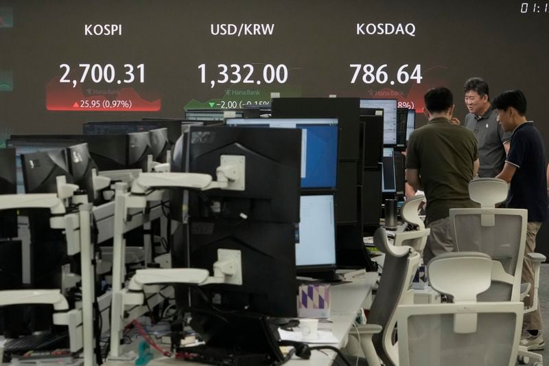 Currency traders work near a screen showing the Korea Composite Stock Price Index (KOSPI), top left, and the foreign exchange rate between U.S. dollar and South Korean won, top center, at the foreign exchange dealing room of the KEB Hana Bank headquarters in Seoul, South Korea, Tuesday, Aug. 20, 2024. (AP Photo/Ahn Young-joon)