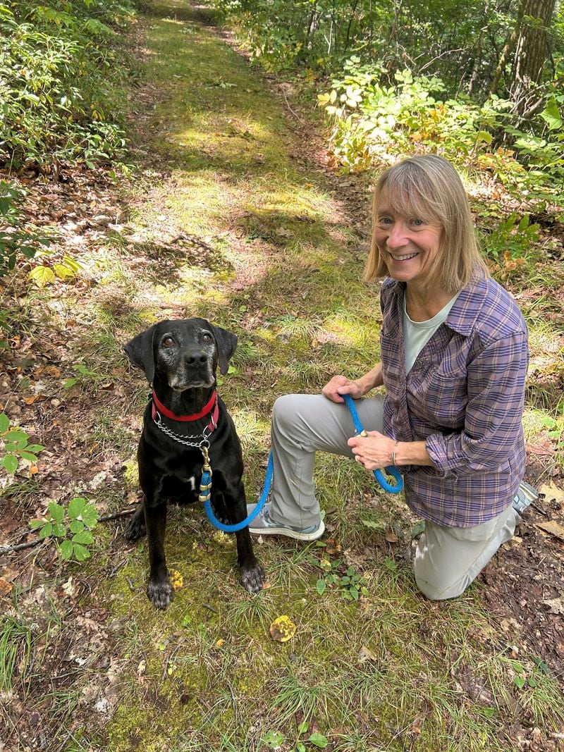 Susannah Johnston, of Croton-on-Hudson, N.Y., poses her dog Ellie on Sept. 8, 2024 in Norfolk, Conn. Johnston, a fit yoga instructor and strength trainer, has been injured three times in incidents involving walking her dog. (Vincent Cohan via AP)