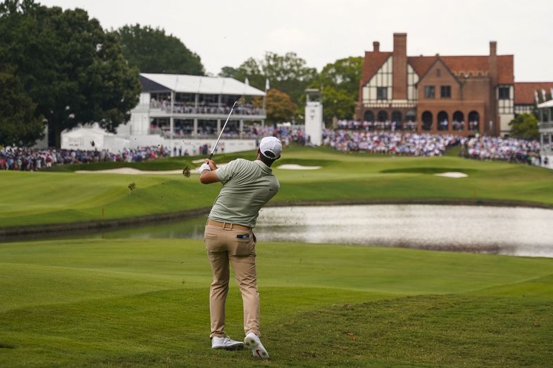 Scottie Scheffler hits in to the 18th green during the final round of the Tour Championship golf tournament, Sunday, Sept. 1, 2024, in Atlanta. (AP Photo/Jason Allen)