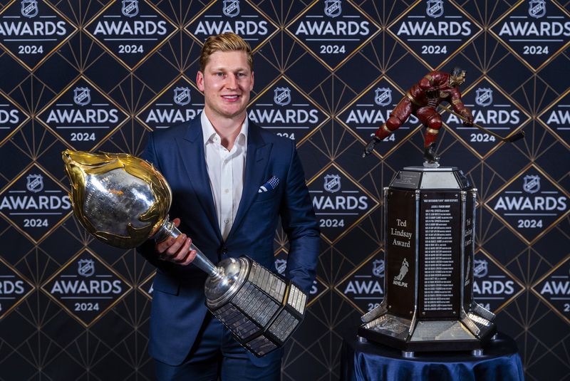 Colorado Avalanche forward Nathan MacKinnon stands with his trophies as the recipient of the Hart Memorial Trophy, left, and Ted Lindsay Award at hockey's NHL Awards, Thursday, June 27, 2024, in Las Vegas. (AP Photo/L.E. Baskow)