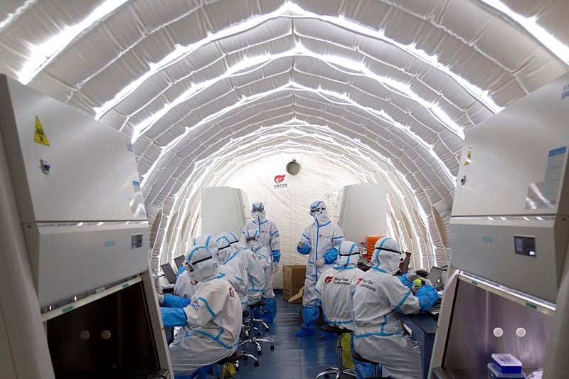 FILE - In this file photo released by China's Xinhua News Agency, staff members work in an inflatable COVID-19 testing lab provided by Chinese biotech company BGI Genomics, a subsidiary of BGI Group, in Beijing, June 23, 2020. (Chen Zhonghao/Xinhua via AP, File)