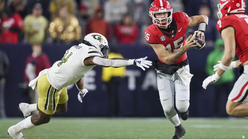 Georgia quarterback Carson Beck (15) gets past Georgia Tech linebacker Braelen Oliver (4) during the fourth quarter at Bobby Dodd Stadium, Saturday, November 25, 2023, in Atlanta. Georgia won 31-23. (Jason Getz / Jason.Getz@ajc.com)