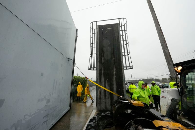 Workers from the Southeast Louisiana Flood Protection Authority-West close floodgates along the Harvey Canal, just outside the New Orleans city limits, in anticipation of Tropical Storm Francine, in Harvey, La., Tuesday, Sept. 10, 2024. (AP Photo/Gerald Herbert)