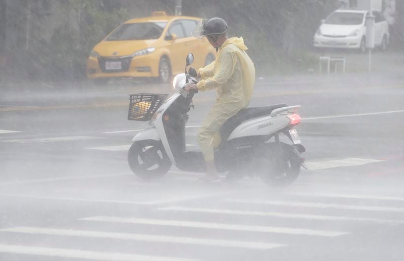 A man struggles in the heavy wind and rain generated by Typhoon Krathon in Kaohsiung, southern Taiwan, Thursday, Oct. 3, 2024. (AP Photo/Chiang Ying-ying)