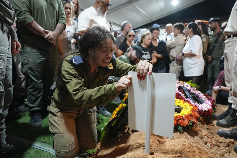 The sister of Petty Officer 1st Class David Moshe Ben Shitrit, who was killed on a Hezbollah attack, mourns during his funeral at the Mount Herzl military cemetery in Jerusalem, Sunday, Aug. 25, 2024. (AP Photo/Ohad Zwigenberg)