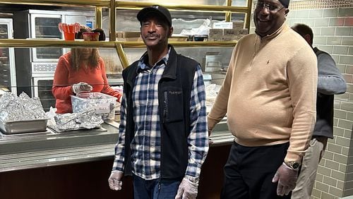 James Simmons (left) and Kelvin Boykin of Redemption After Prison (RAP) serve food at the Sunday morning prayer breakfast for the homeless and hungry at First Presbyterian Church of Atlanta. (Gayle White for The Atlanta Journal-Constitution)