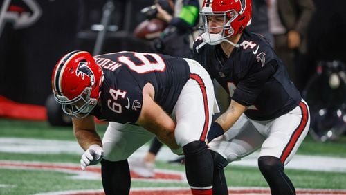 Atlanta Falcons quarterback Taylor Heinicke (4) warms up with a snap from guard Ryan Neuzil (64) before a NFL football game between the Atlanta Falcons and the New Orleans Saints in Atlanta on Sunday, Nov. 26, 2023.   (Bob Andres for the Atlanta Journal Constitution)