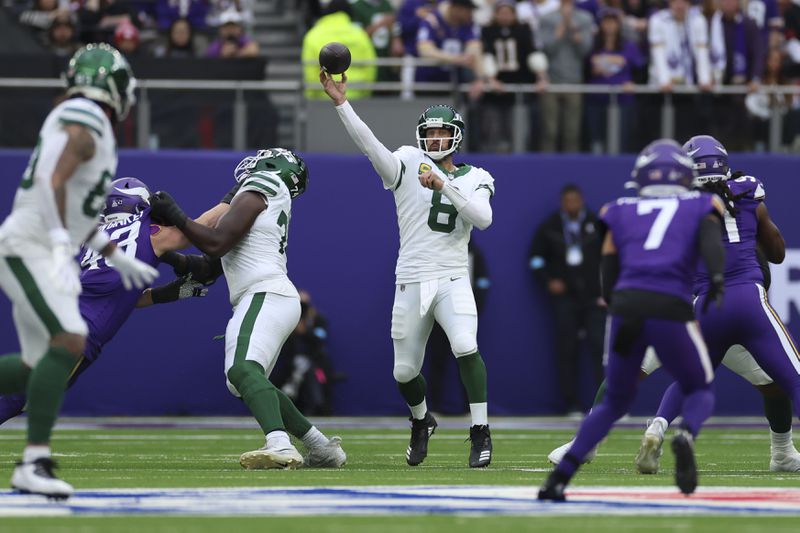 New York Jets quarterback Aaron Rodgers, center, throws during the first half of an NFL football game against the Minnesota Vikings, Sunday, Oct. 6, 2024, at the Tottenham Hotspur stadium in London. (AP Photo/Ian Walton)