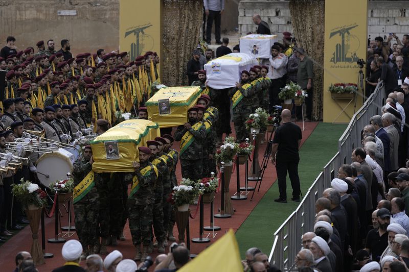 Hezbollah fighters carry the coffins of fallen four comrades who were killed Monday after their handheld pagers exploded, during their funeral procession in the southern suburb of Beirut, Lebanon, Wednesday, Sept. 18, 2024. (AP Photo/Bilal Hussein)