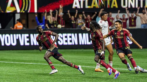 Atlanta United forward Jamal Thiaré, left, midfielder Tristan Muyumba, center, and forward Tyler Wolff, right, celebrate after the winning goal during the second half of an MLS soccer match against Toronto FC, Saturday, June 29, 2024, in Atlanta. (AP Photo/Danny Karnik)