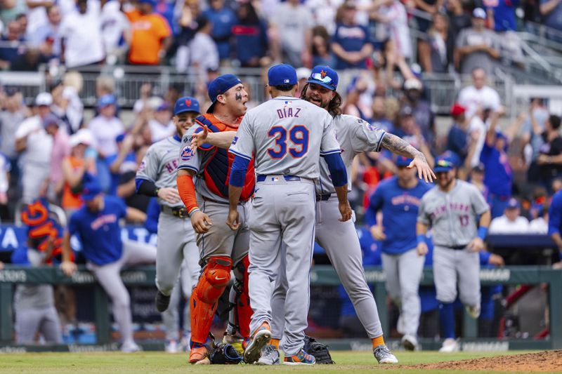 New York Mets pitcher Edwin Díaz, center, celebrates with teammates after winning the game in the ninth inning of a baseball game against the Atlanta Braves, Monday, Sept. 30, 2024, in Atlanta. (AP Photo/Jason Allen)