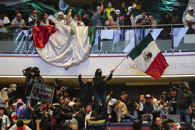 Protesters interrupt a Senate session in which lawmakers were debating the government's proposed judicial reform, which would make judges stand for election, in Mexico City, Tuesday, Sept. 10, 2024. (AP Photo/Felix Marquez)