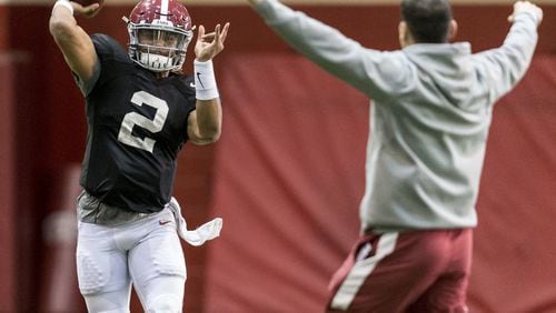 Alabama quarterback Jalen Hurts (2) throws around offensive coordinator Steve Sarkisian during a quarterback drill at football practice, Wednesday, Jan. 4, 2017, in Tuscaloosa, Ala. (Vasha Hunt /AL.com via AP)