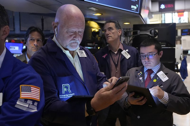 FILE - Robert Moran, left, works with fellow traders on the floor of the New York Stock Exchange, Friday, Aug. 16, 2024. (AP Photo/Richard Drew, File)