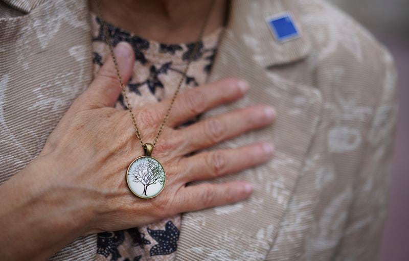 Audrey Glickman, a Tree of Life member who survived the 2018 attack, holds a necklace representing the synagogue, Friday, Sept. 27, 2024, in Pittsburgh. (AP Photo/Jessie Wardarski)