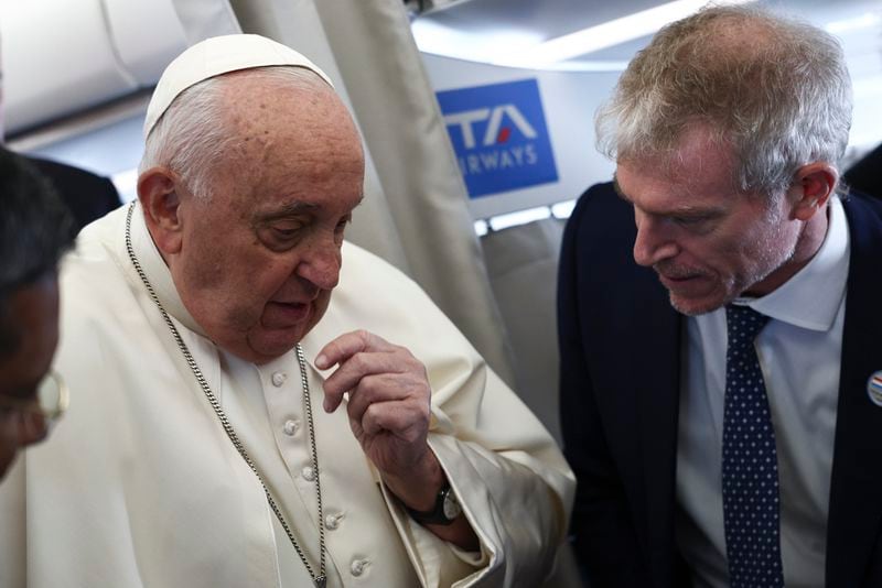 Pope Francis, leaft, speaks aboard his flight bound for Luxembourg, where he will start a four-day apostolic journey in Luxembourg and Belgium, Thursday, Sept. 26, 2024. (Guglielmo Mangiapane/Pool Photo via AP)