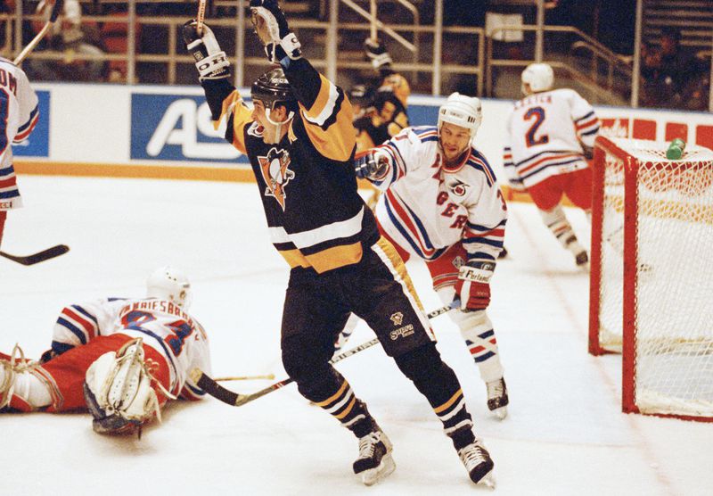 FILE - Pittsburgh Penguins Kevin Stevens celebrates teammate Jaromir Jagr's second goal as New York Rangers goaltender John Vanbiesbrouck, left, and Paul Broten, right, regroup in the third period of 3-2 Penguins win at New York's Madison Square Garden, Monday, May 12, 1992. (AP Photo/Bill Kostroun, File)