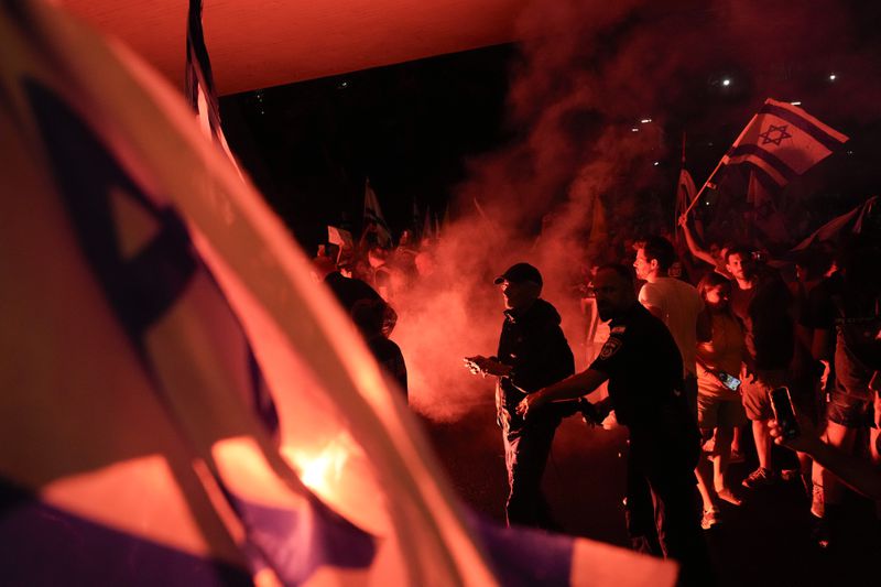 People block a road as they protest calling for a deal for immediate release of hostages held in the Gaza Strip by the Hamas militant group, in Tel Aviv, Sunday, Sept. 1, 2024. (AP Photo/Ariel Schalit)