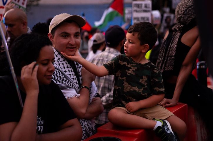 Yaseen, 4, a Palestinian resident of Atlanta, interacts with pro-Palestine protesters near the intersection of 10th Street NW and Spring Street NW in Atlanta on Thursday, June 27, 2024. Nearby, President Joe Biden and former President Donald Trump participated in a debate hosted by CNN. (Seeger Gray / AJC)